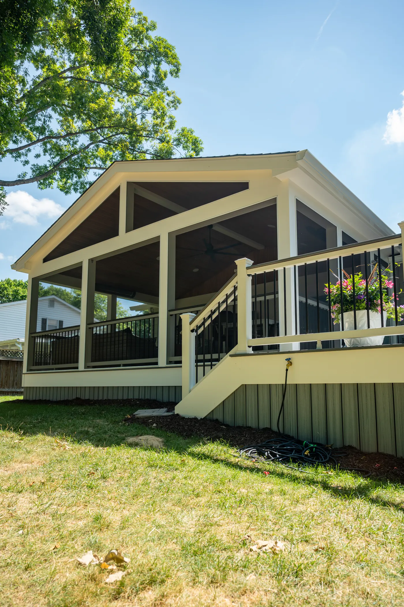 Gabled screened porch on a deck with white railing