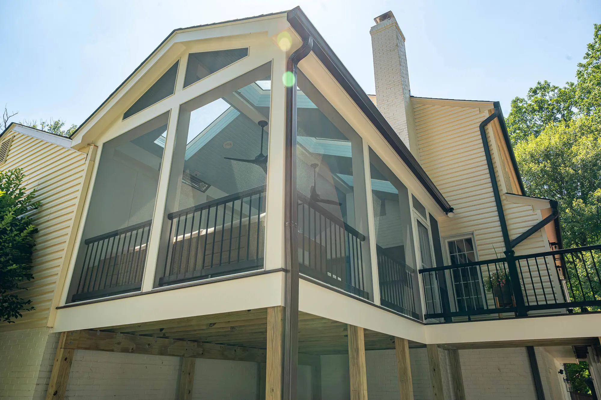 Two-story screened porch with a vaulted roof and skylights above a deck